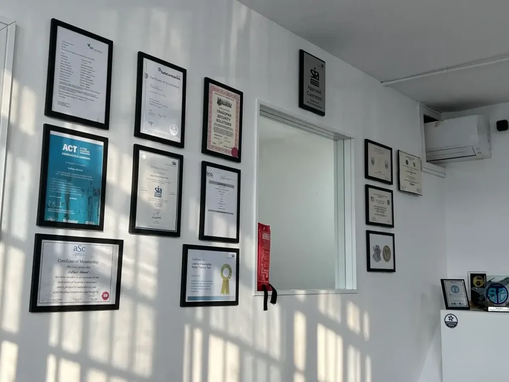 Image of a wall filled of different certifications and a glass window.